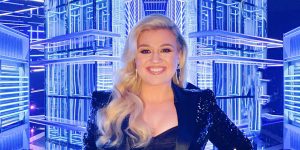 Cantora pop Kelly Clarkson sorrindo e fundo luminoso