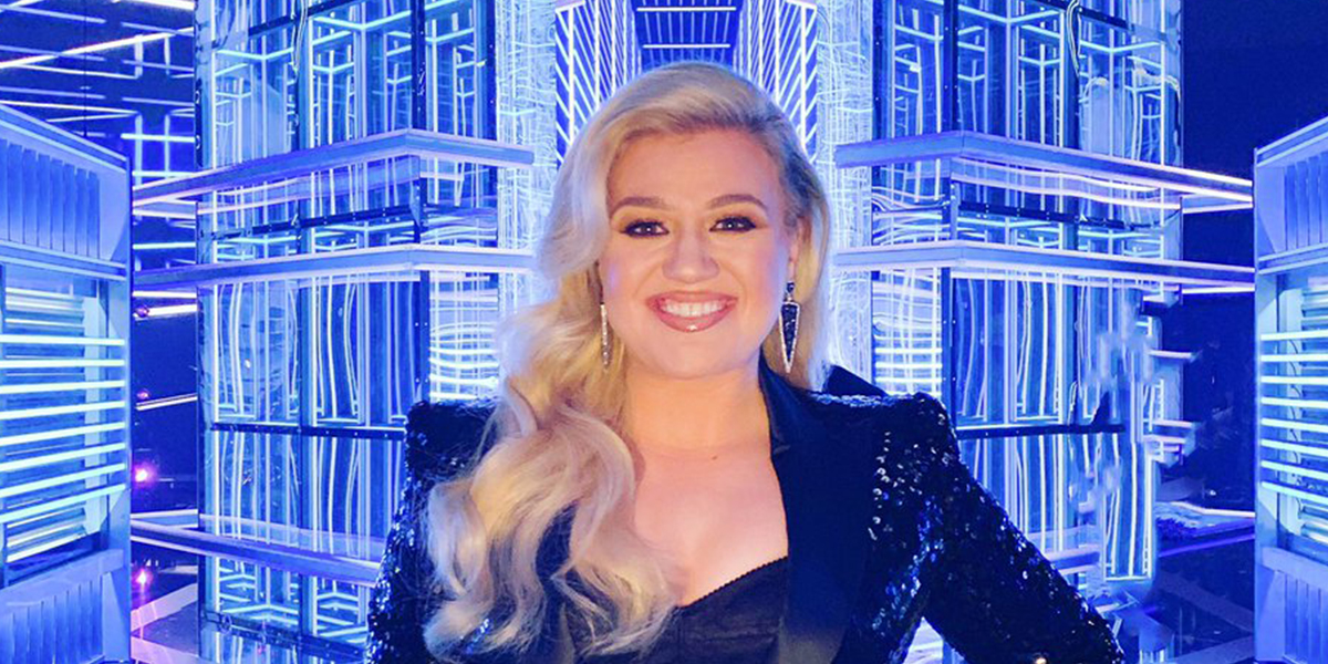 Cantora pop Kelly Clarkson sorrindo e fundo luminoso