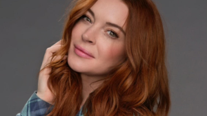 Foto da atriz Lindsay Lohan com rosto levemente curvado para cima e mão esquerda no cabelo.