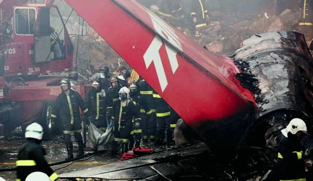 Imagem do resgate após o acidente com o voo 3054 da TAM, em julho de 2007, no Aeroporto de Congonhas. Bombeiros trabalham entre os destroços do avião em meio a fumaça e incêndio, com a cauda da aeronave visível ao fundo.
