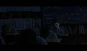 Criança com expressão assustadora em sala de aula escura no filme “A Hora do Mal”, novo terror com Julia Garner e Josh Brolin