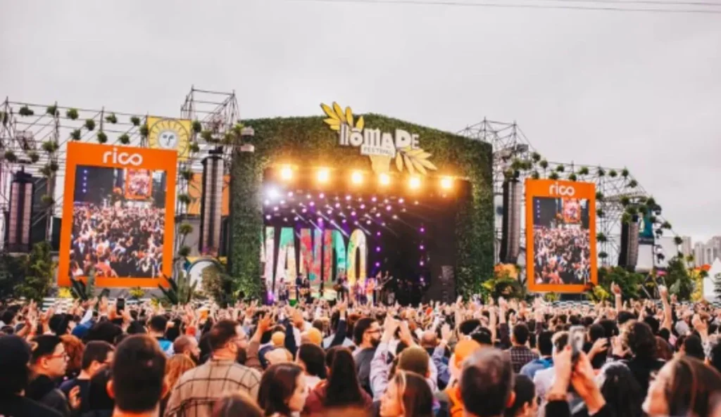 Público acompanha show no palco principal do Nômade Festival, com telões laterais e decoração inspirada na natureza, no Parque Villa Lobos, em São Paulo