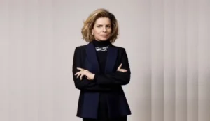 Debora Bloch caracterizada como Odete Roitman no remake da novela 'Vale Tudo', da Globo. A atriz aparece de braços cruzados, usando blazer escuro e expressão séria