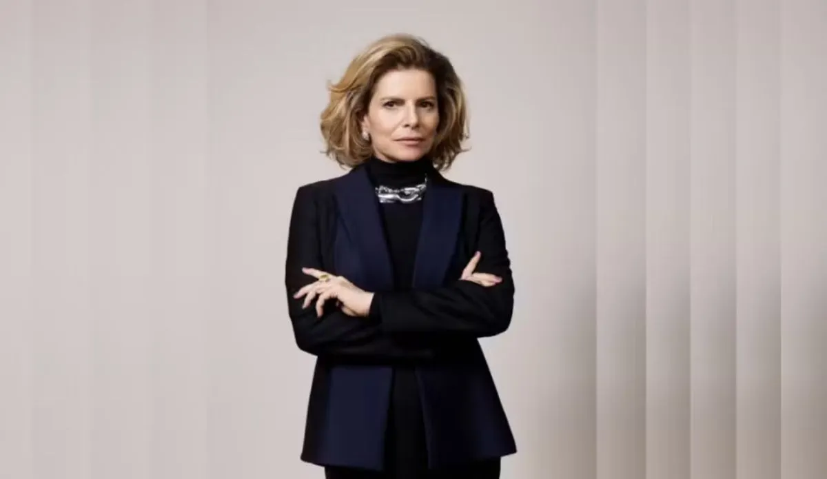 Debora Bloch caracterizada como Odete Roitman no remake da novela 'Vale Tudo', da Globo. A atriz aparece de braços cruzados, usando blazer escuro e expressão séria
