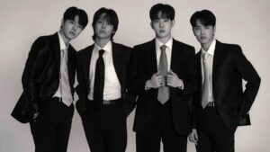 the rose volta ao brasil para apenas um show. grupo com quatro integrantes vestindo ternos e foto em preto e branco
