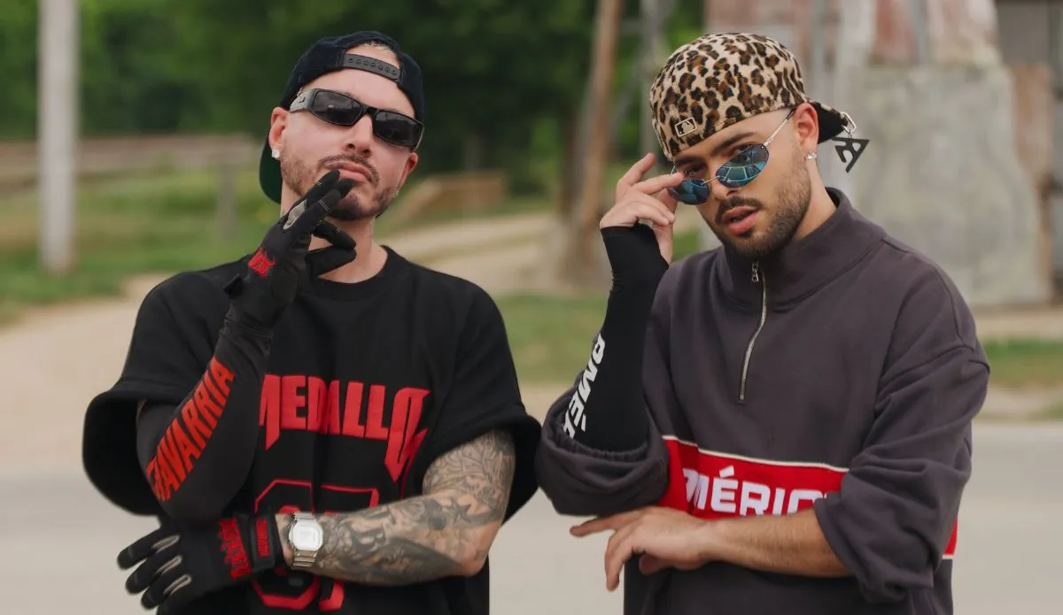 Pedro Sampaio e J Balvin posam juntos em clima urbano, usando óculos escuros e looks estilosos, para promover o single “Perversa”