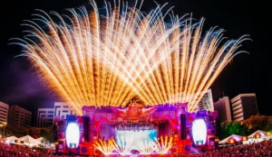 Palco principal do Rap in Cena 2024 em Porto Alegre, iluminado por fogos de artifício durante apresentação noturna do festival.