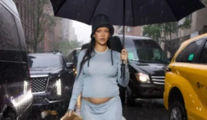 Rihanna caminha sob chuva em Nova York usando look azul claro e exibindo a barriga de grávida antes do Met Gala 2025