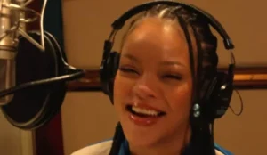 Rihanna sorrindo em estúdio de gravação enquanto dubla e canta para o novo filme dos Smurfs, que contará com sua nova música “Friend of Mine”.