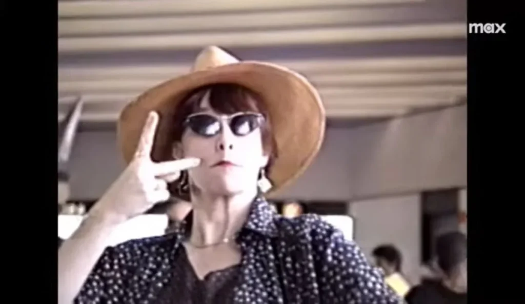 Rita Lee usando chapéu de palha, óculos escuros e fazendo o sinal de paz com os dedos, em imagem de arquivo exibida no documentário “Rita Lee: Mania de Você” da Max.