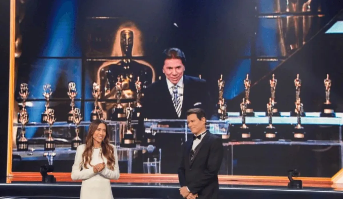 Patricia Abravanel e Celso Portiolli no palco do Troféu Imprensa 2025, com troféus ao fundo e uma grande tela exibindo Silvio Santos em imagem de arquivo, durante homenagem ao apresentador.