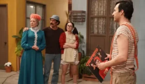 Cena da série 'Chespirito: Sem Querer Querendo', da HBO Max, com atores caracterizados como Dona Clotilde, Seu Madruga, Chiquinha e Chaves em um set que recria a vila clássica do seriado.