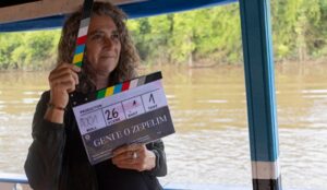 A diretora Anna Muylaert segura claquete do filme “Geni e o Zepelim” durante gravação em um barco no rio Moa, no Acre.
