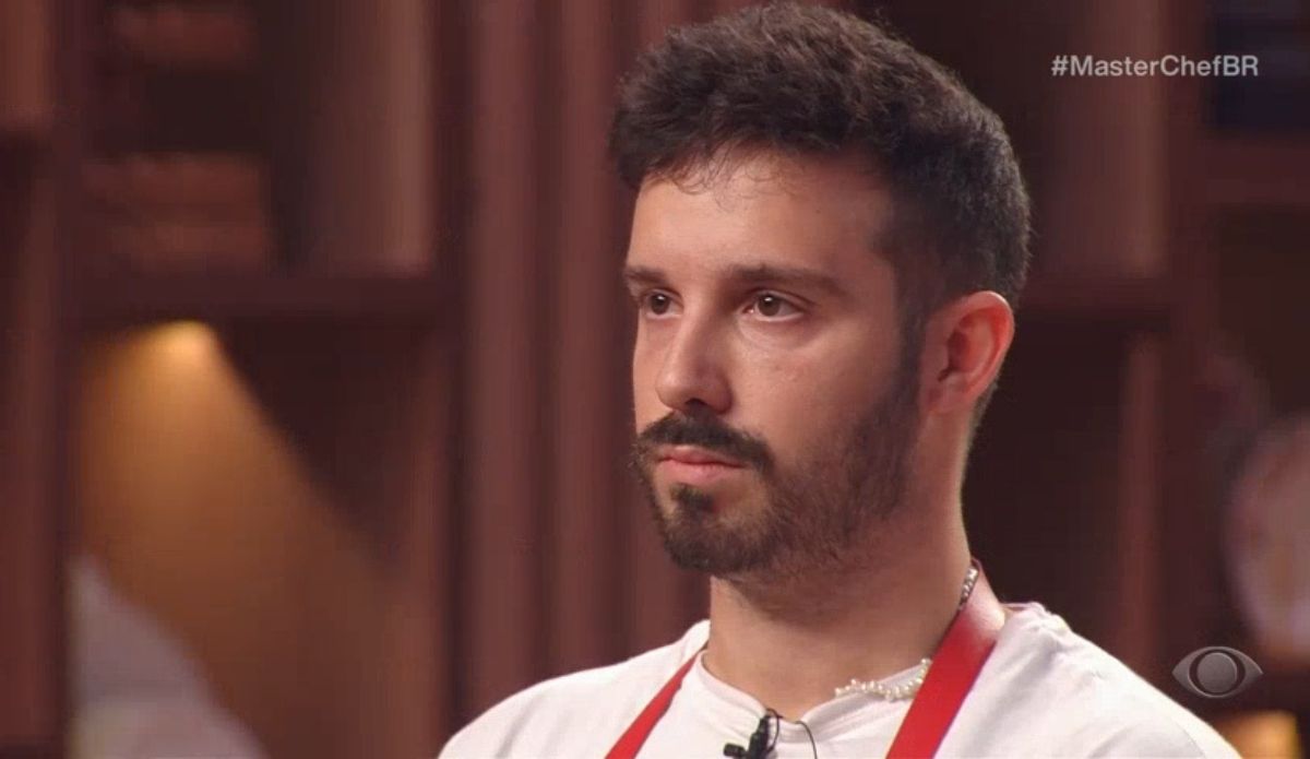 Lucas, participante do MasterChef Brasil 2025, olha sério e visivelmente abalado após receber críticas dos jurados, momentos antes de ser eliminado na prova do raviolone de gema.