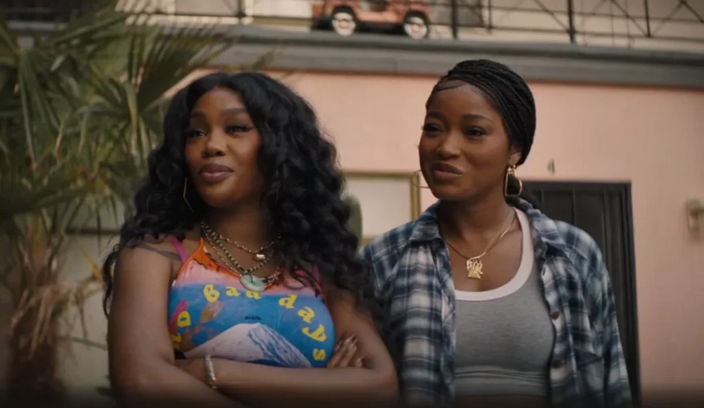 SZA e Keke Palmer em cena do filme Um Dia Daqueles; personagens Alyssa e Dreux aparecem lado a lado em frente a um prédio, com expressões confiantes.