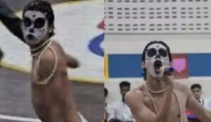 Adolescente Yago Savalla caracterizado como Ney Matogrosso durante performance escolar. Ele aparece com o rosto pintado de branco com detalhes pretos, usando colares de pérola e sem camisa, em duas cenas da apresentação: uma em movimento e outra segurando um microfone