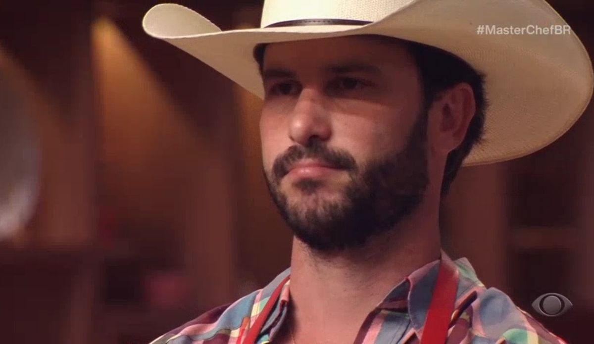 André, participante do MasterChef Brasil 2025, de chapéu e avental vermelho, no momento de sua eliminação durante o episódio exibido em 1º de julho