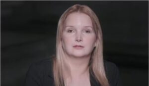 Elize Matsunaga durante depoimento na série documental "Elize Matsunaga: Era Uma Vez um Crime", da Netflix. Ela aparece com expressão neutra, usando blazer preto e cabelos loiros soltos, em fundo escuro.