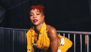 Karol Conká posa nos bastidores com look amarelo vibrante e cabelos ruivos presos