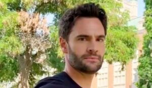 Tom Bateman em imagem recente ao ar livre; ator foi confirmado como Adam Carlsen na adaptação de “A Hipótese do Amor”