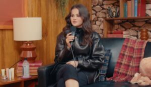 Selena Gomez segurando um microfone durante entrevista ao podcast "Therapuss with Jake Shane".