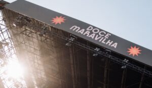 Palco do Festival Doce Maravilha, com o letreiro do evento em destaque e estrutura de iluminação contra o céu claro.