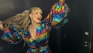 Natasha Bedingfield sorrindo e posando com um vestido colorido de mangas volumosas; cantora sobe ao palco do The Town neste sábado (13)