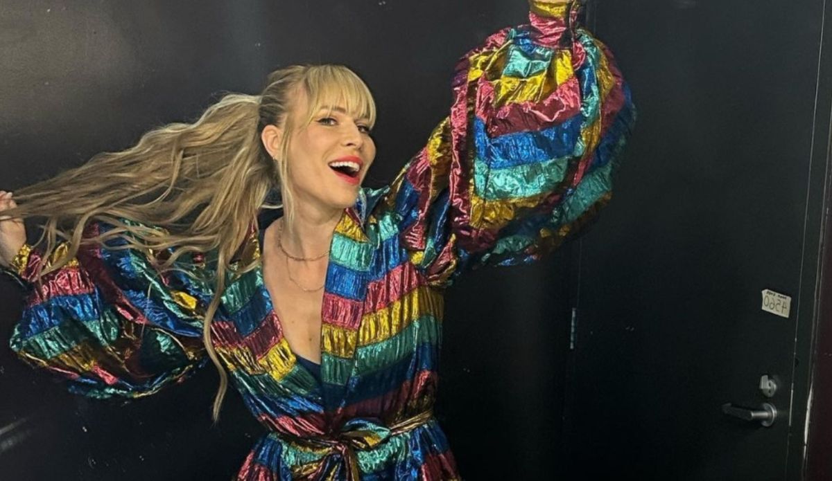 Natasha Bedingfield sorrindo e posando com um vestido colorido de mangas volumosas; cantora sobe ao palco do The Town neste sábado (13)