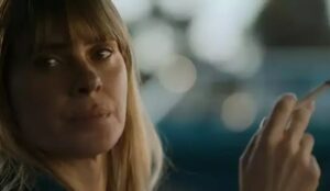 Cena de Carolina Dieckmann no filme "Pequenas Criaturas", com expressão séria segurando um cigarro; com iluminação suave e fundo desfocado.