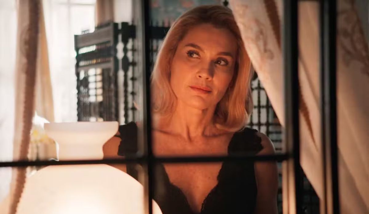 Sandra (Flávia Alessandra) observa através da janela, com expressão séria e olhar pensativo, em cena da novela Êta Mundo Melhor! da TV Globo; confira o resumo da semana (06 a 11 de outubro)