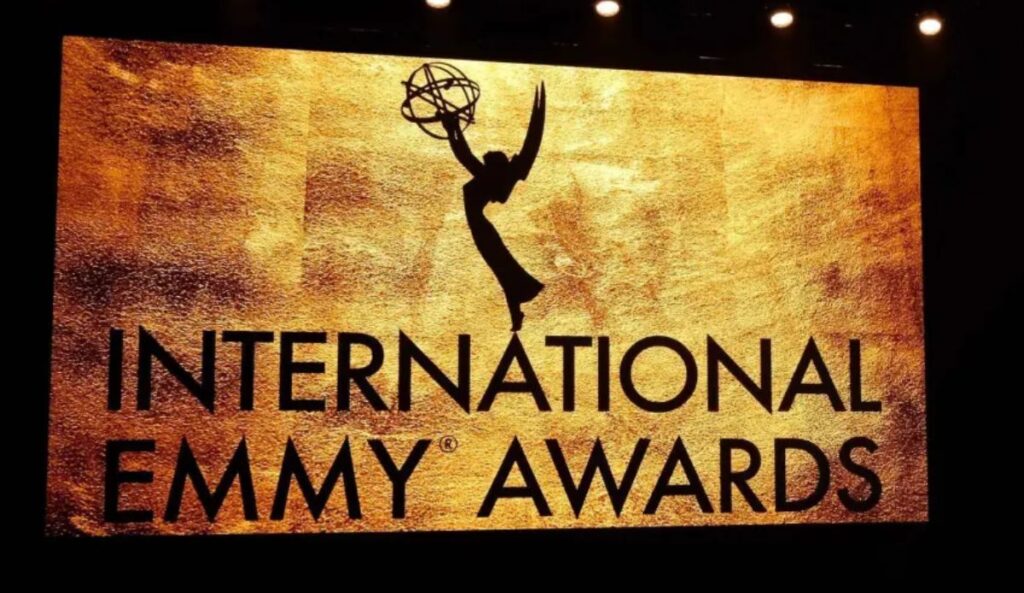 Painel dourado do International Emmy Awards com a silhueta da estatueta do Emmy em destaque durante a cerimônia.