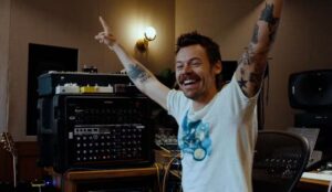Harry Styles aparece sorrindo em estúdio de gravação, comemorando o anúncio de nova música e o início de uma nova fase na carreira.