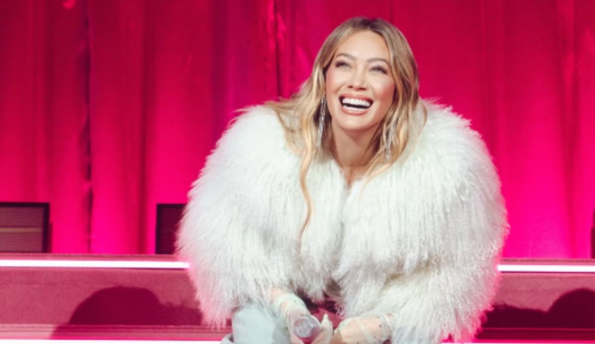 Hilary Duff sorri durante apresentação ao vivo, marcando seu retorno aos palcos em show da nova fase da carreira.