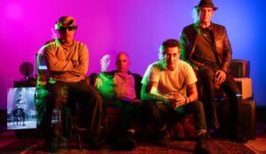 Integrantes do Capital Inicial posam com iluminação neon para divulgar a turnê Música Urbana 2026