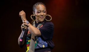Negra Li se apresenta no palco com microfone na mão durante show; rapper fala sobre estreia no Lollapalooza Brasil e trajetória no rap nacional