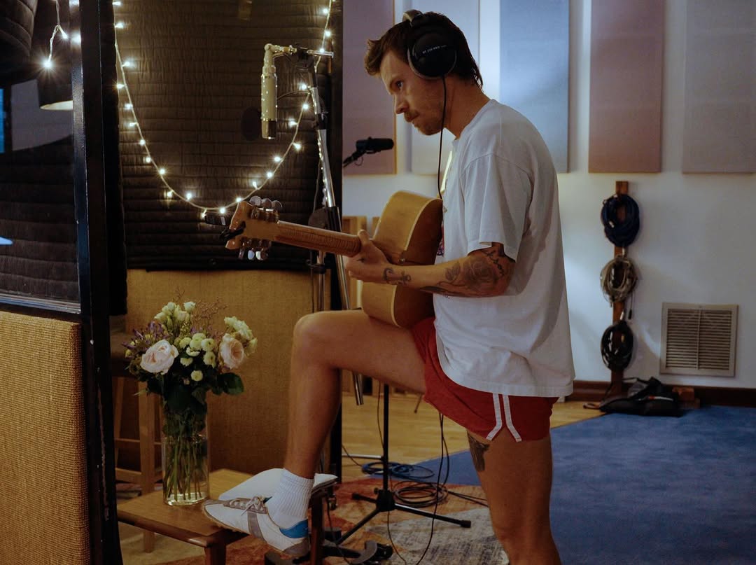 harry styles tocando violão durante a produção do novo álbum "Kiss All The Time. Disco, Occasionally."