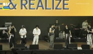 Integrantes do RIIZE no palco do Lollapalooza Brasil 2026 durante show com banda ao vivo e interação em português
