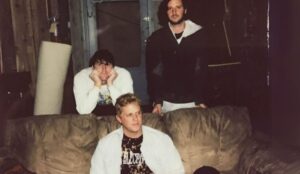 Integrantes da banda indie pop TV Girl reunidos em um sofá; grupo americano se apresenta em show no Cine Joia em São Paulo.