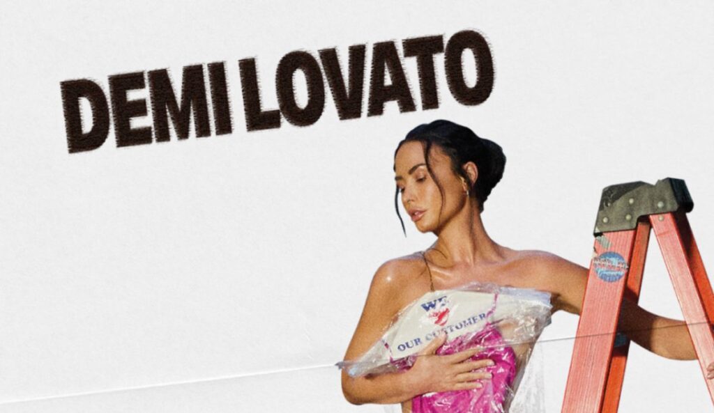 Demi Lovato posa ao lado de uma escada vermelha em imagem de divulgação da turnê “It’s Not That Deep”.