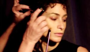 Luisa Arraes durante processo de caracterização para interpretar Cássia Eller em "Cássia - O Filme", enquanto recebe ajustes de maquiagem e cabelo nos bastidores da produção.